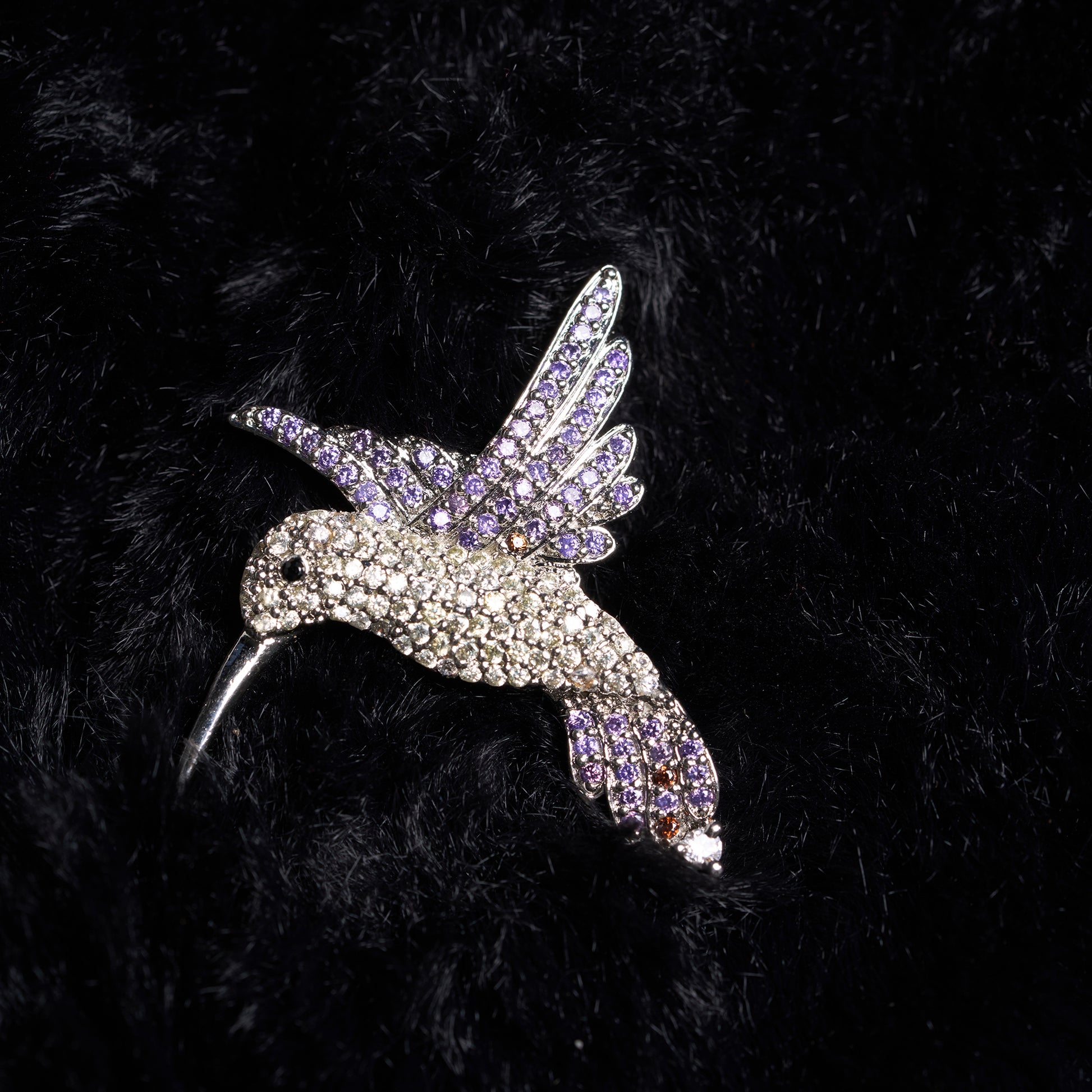 Humming Bird brooch With amethyst and crystal studded on it.