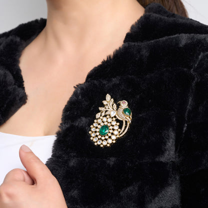 Gold Plated Parrot Brooch with Emerald stone in center on a black fur coat in background by studio6jewels