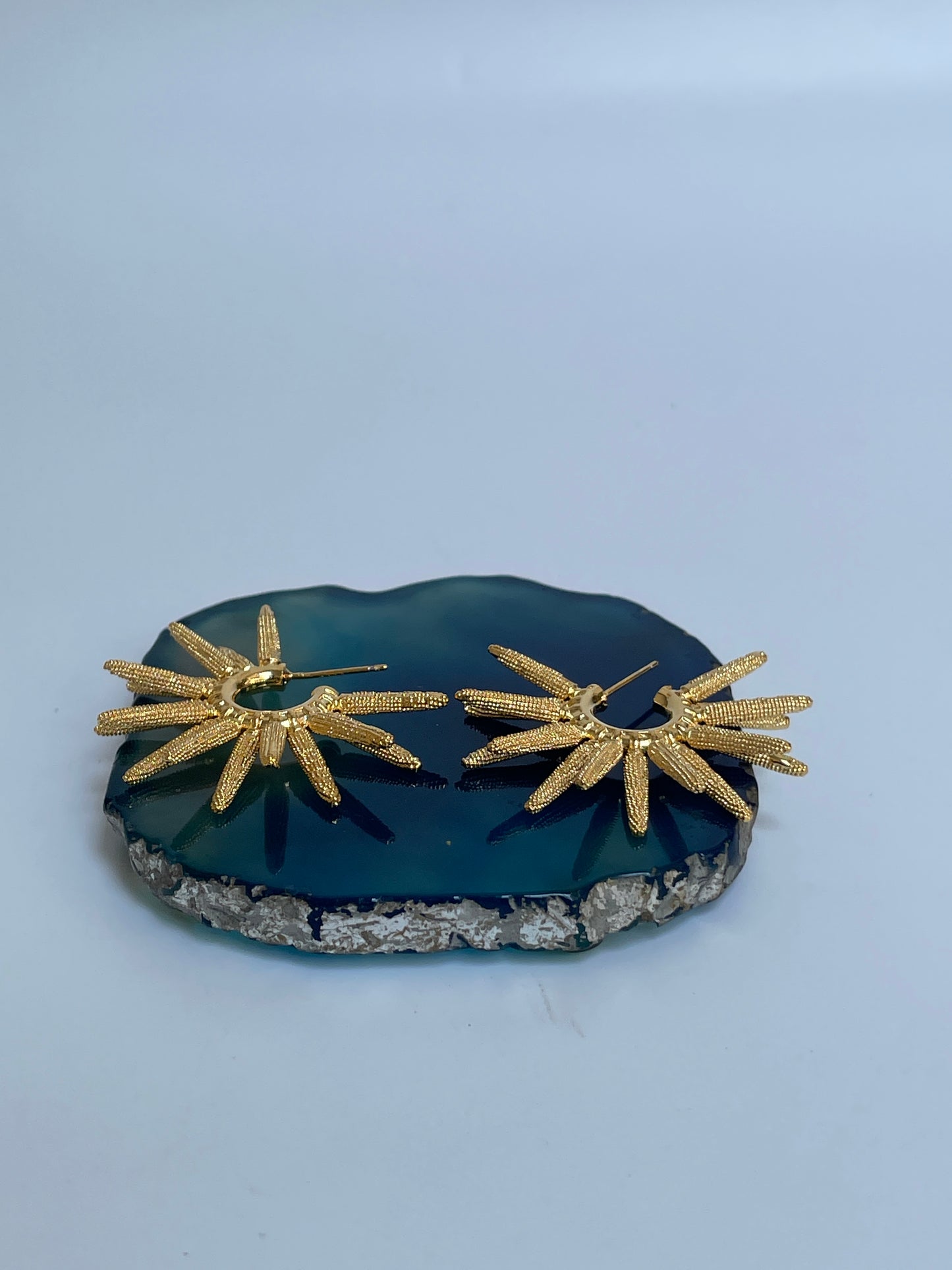 Sun Shaped Hoop earrings on a blue stone surface by studio6 jewels