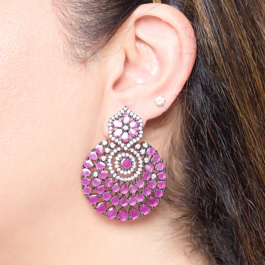 Close-up of a person wearing a pink and silver earring.